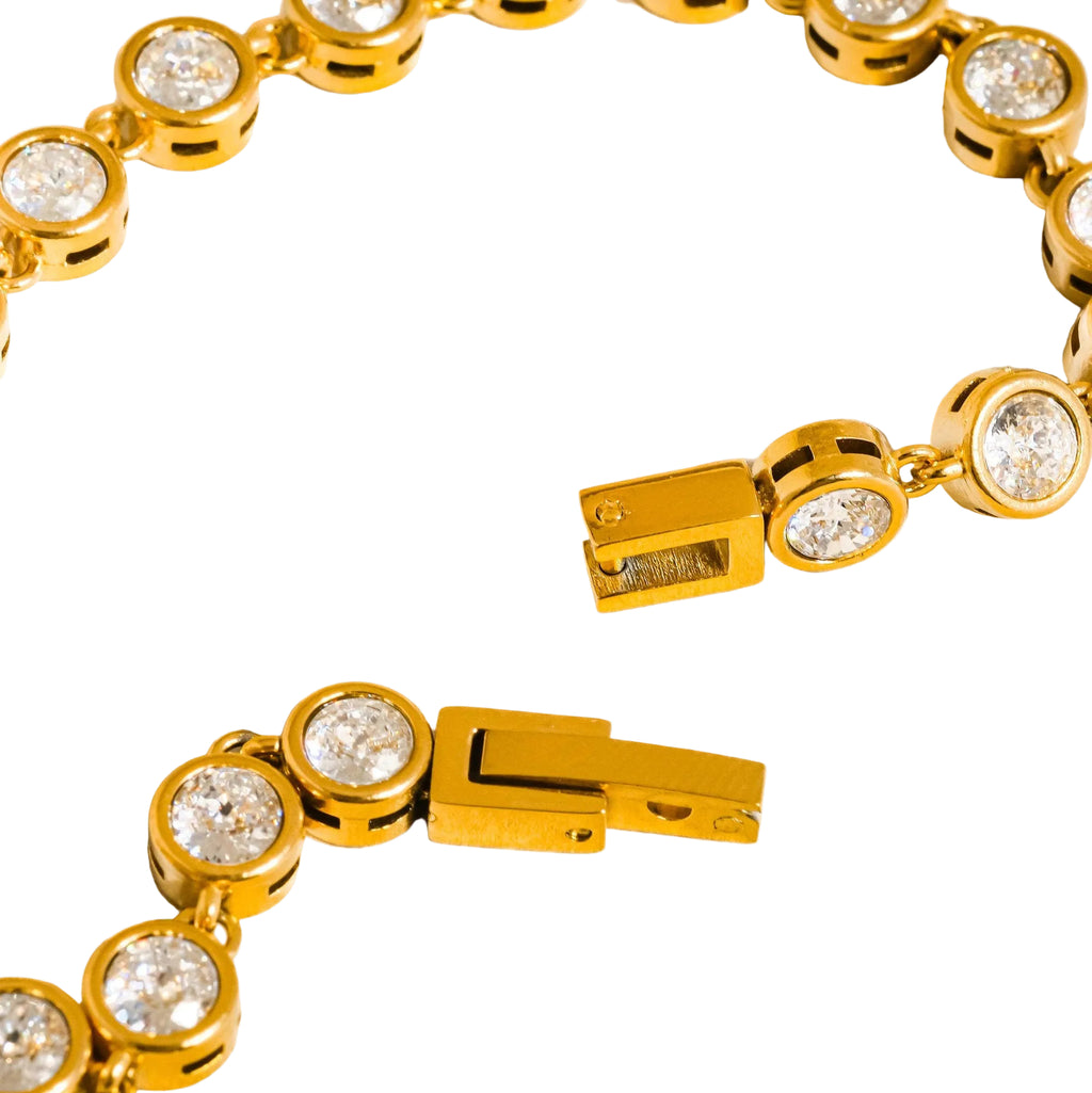 Gold bracelet with clear gemstones on a white background