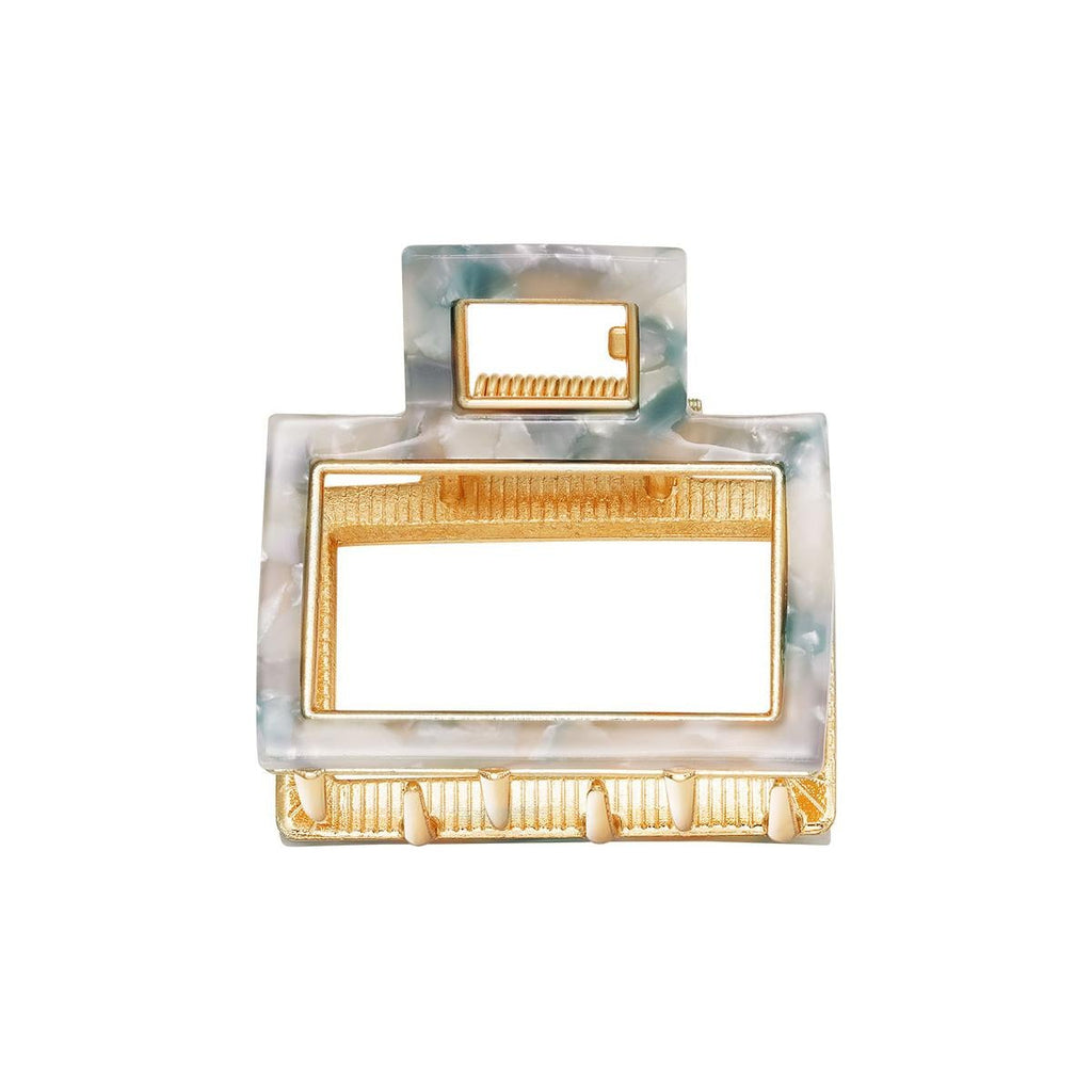Marble-patterned jewelry hair clip with gold accents on a white background