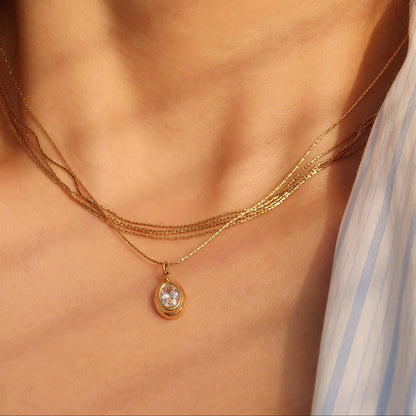 Gold necklace with a pendant on a person's neck
