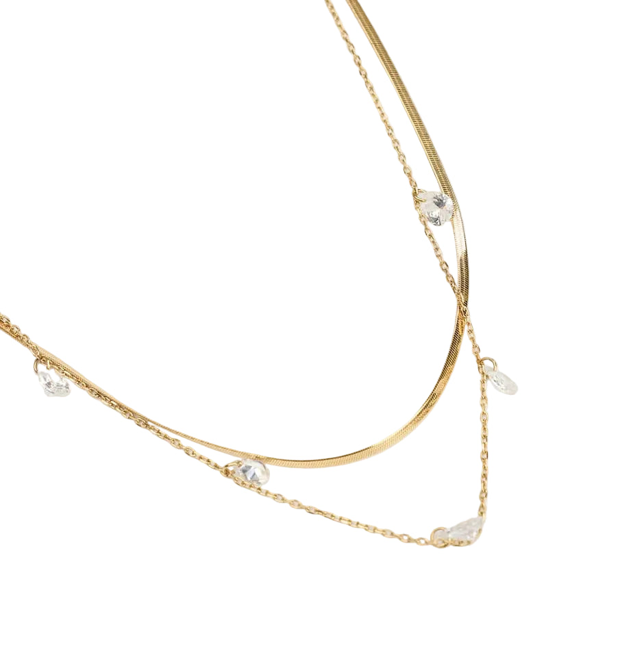 Gold necklace with small pearls on a white background